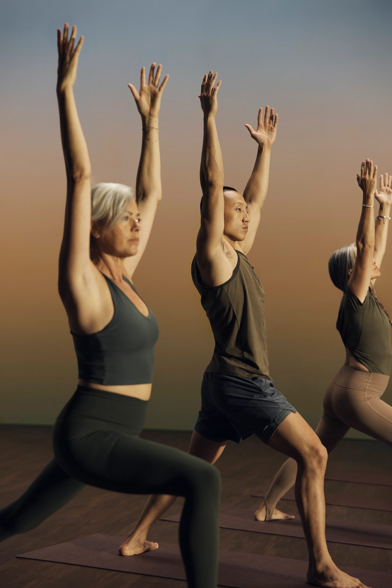 Root yoga class participants in warrior pose at Life Time