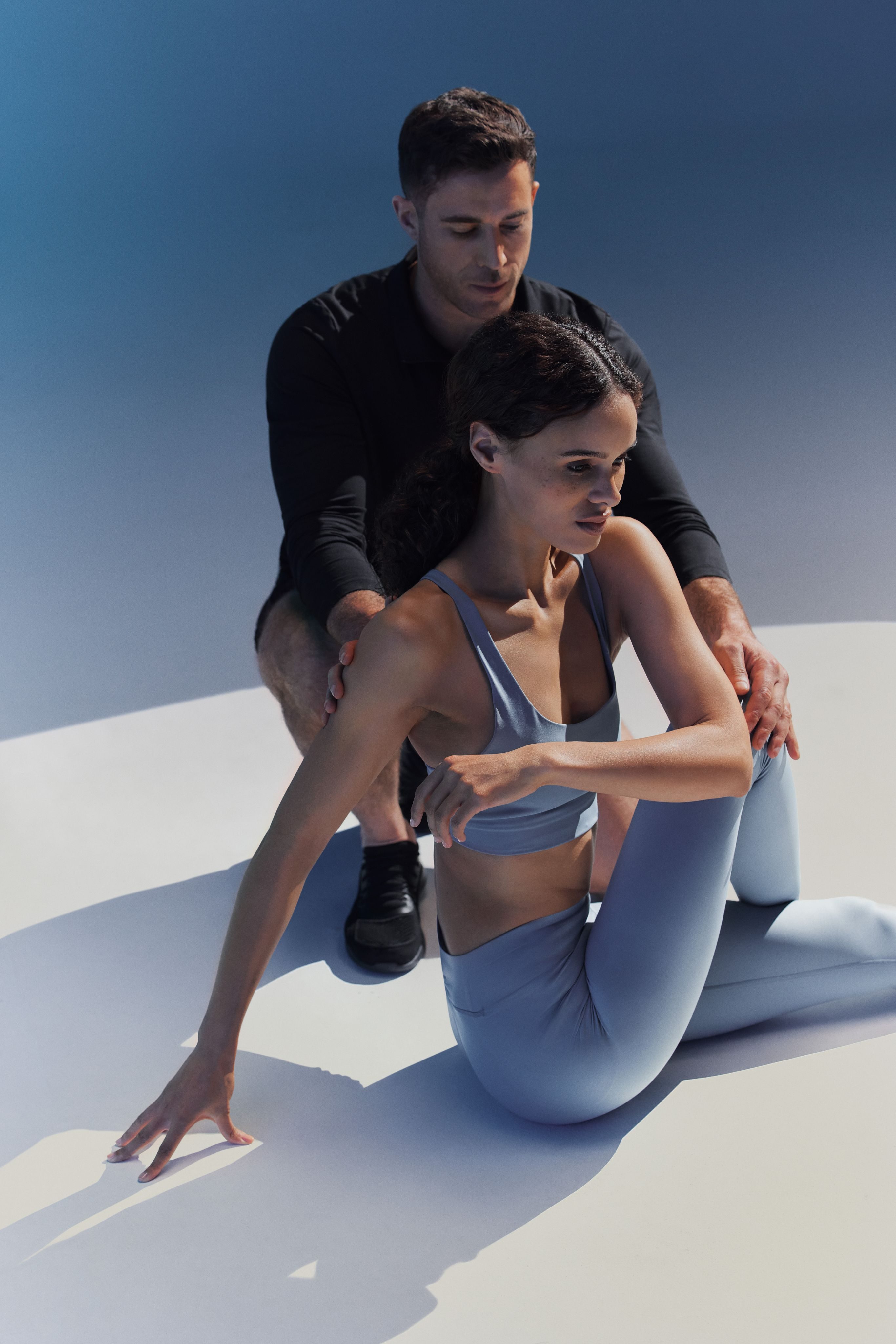 A trainer helping his client stretch