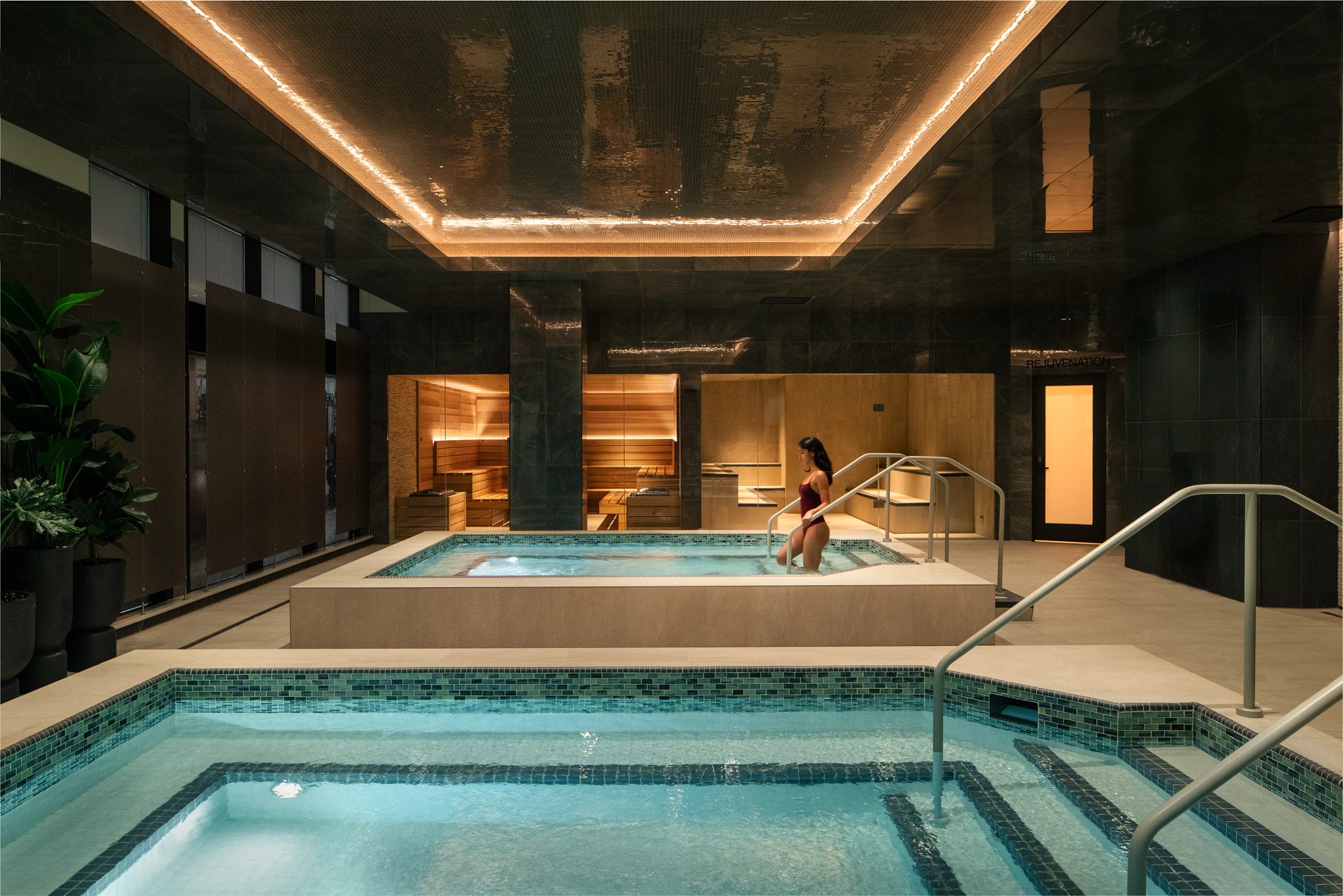 A woman walking into an indoor whirlpool