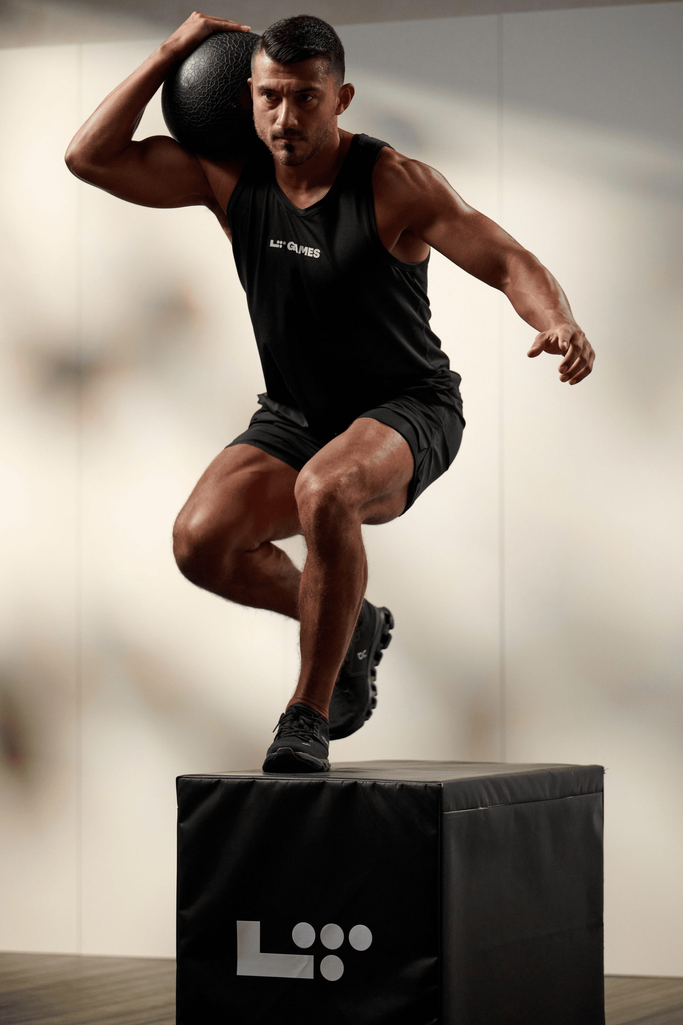 a man doing a box step over with medicine ball