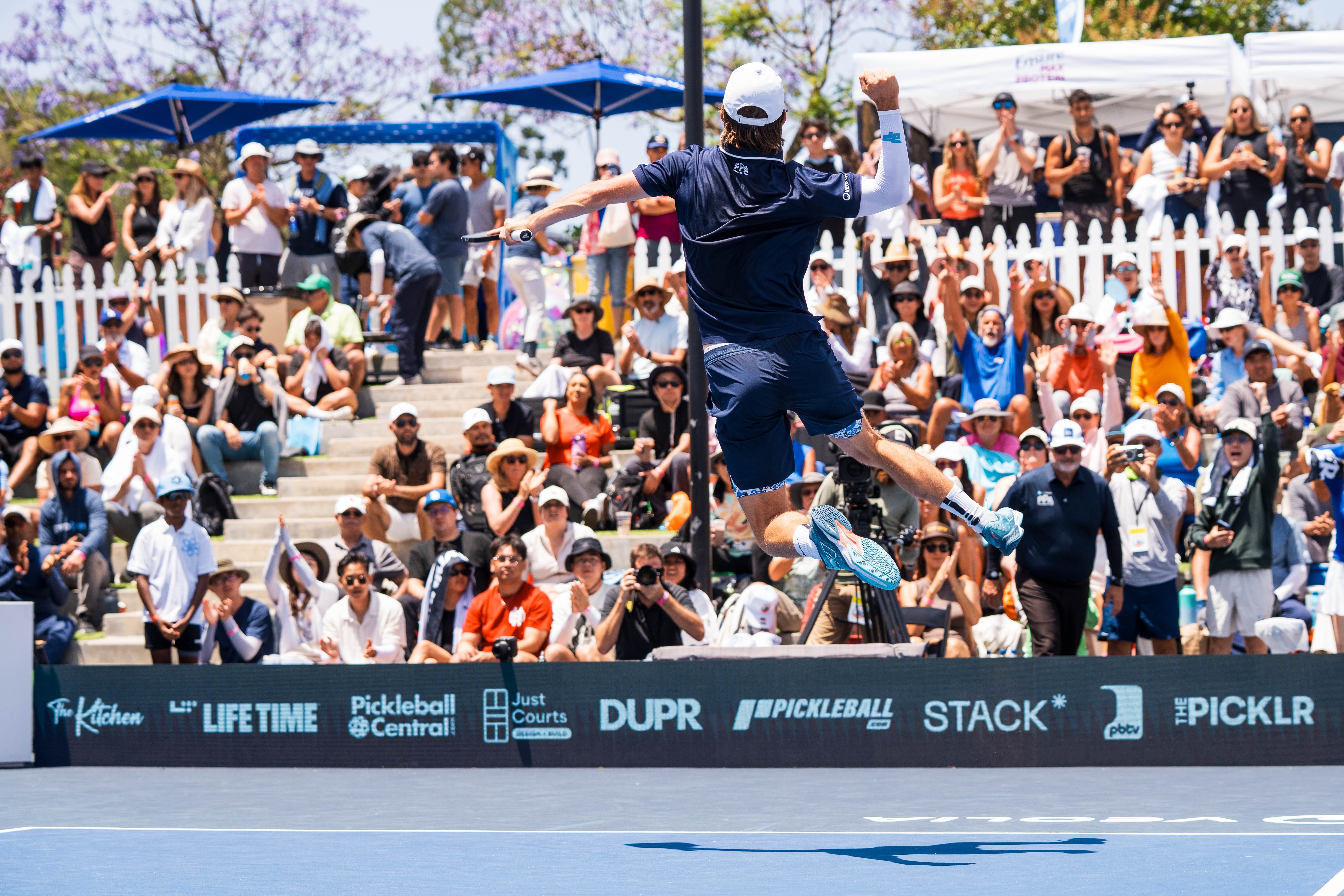 man jumping up in the air to hit a pickleball