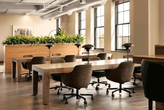 two tables and brown swivel chairs in a coworking space