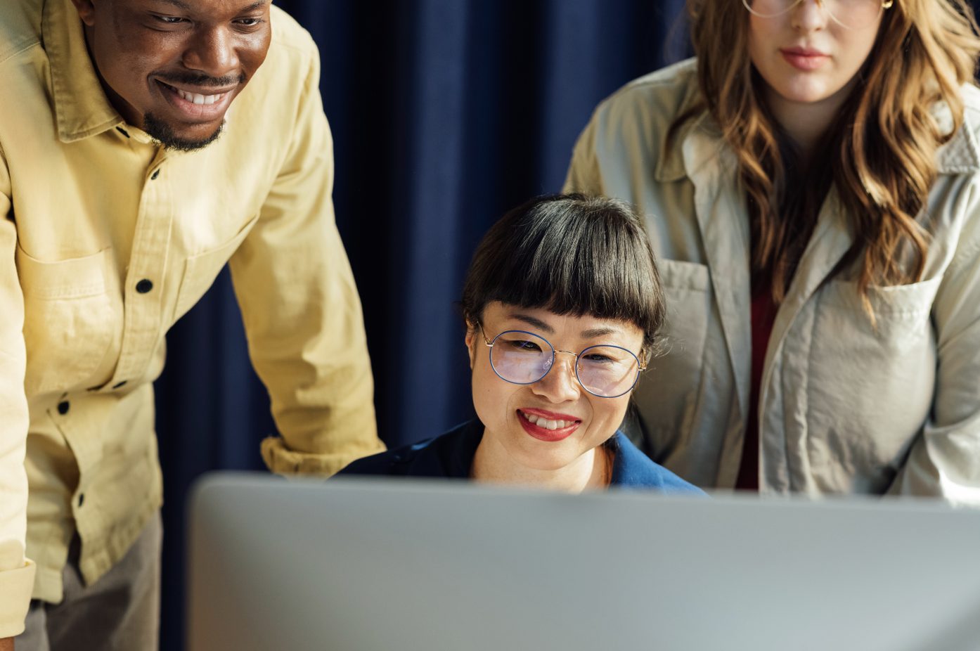 three people looking at a computer