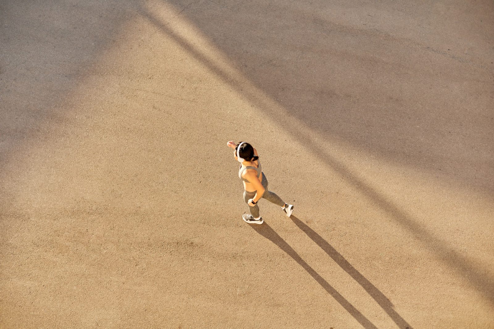 Top view of a young, attractive athletic woman running on city asphalt and training.