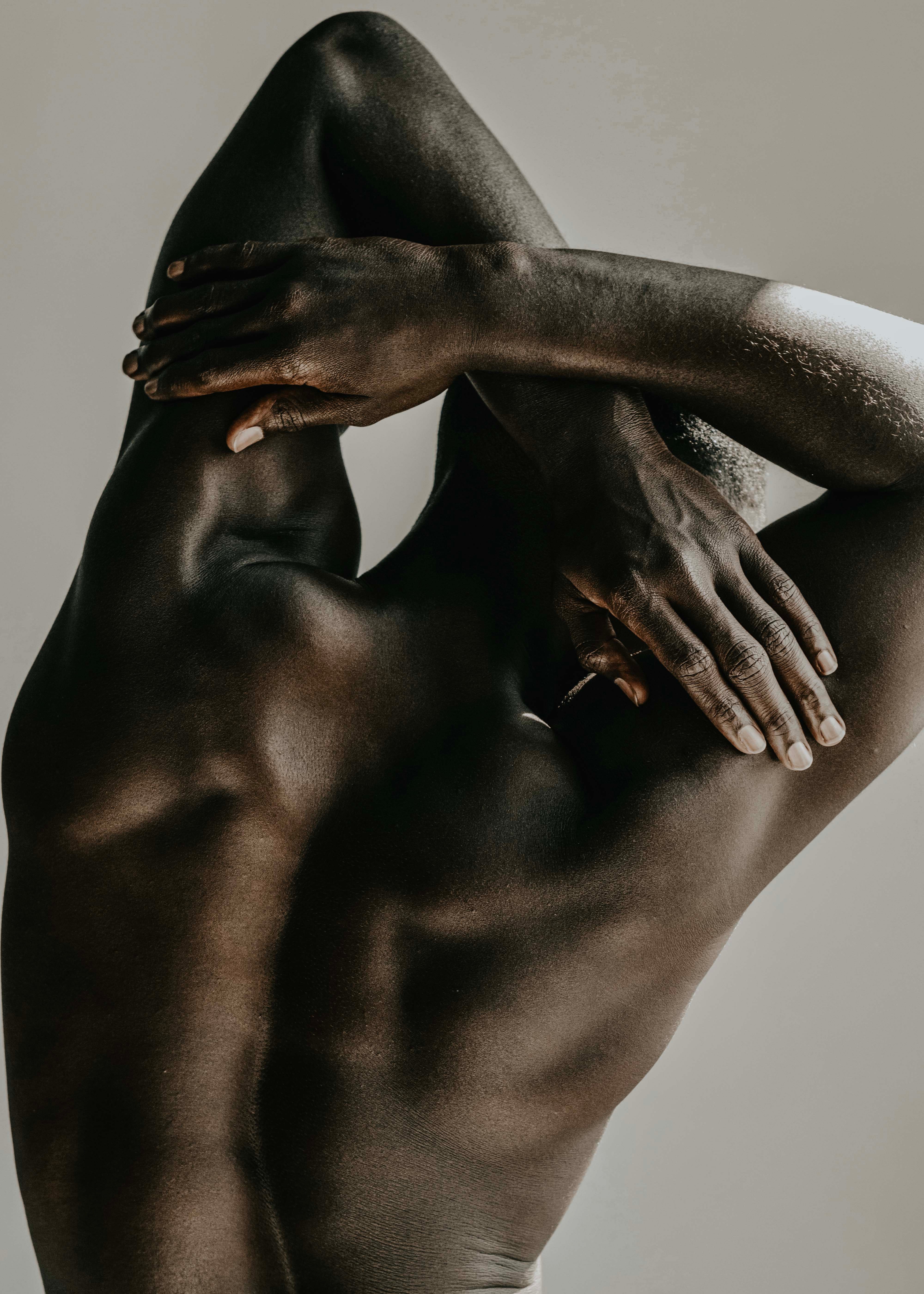 man crossing his arms above his head touching his back