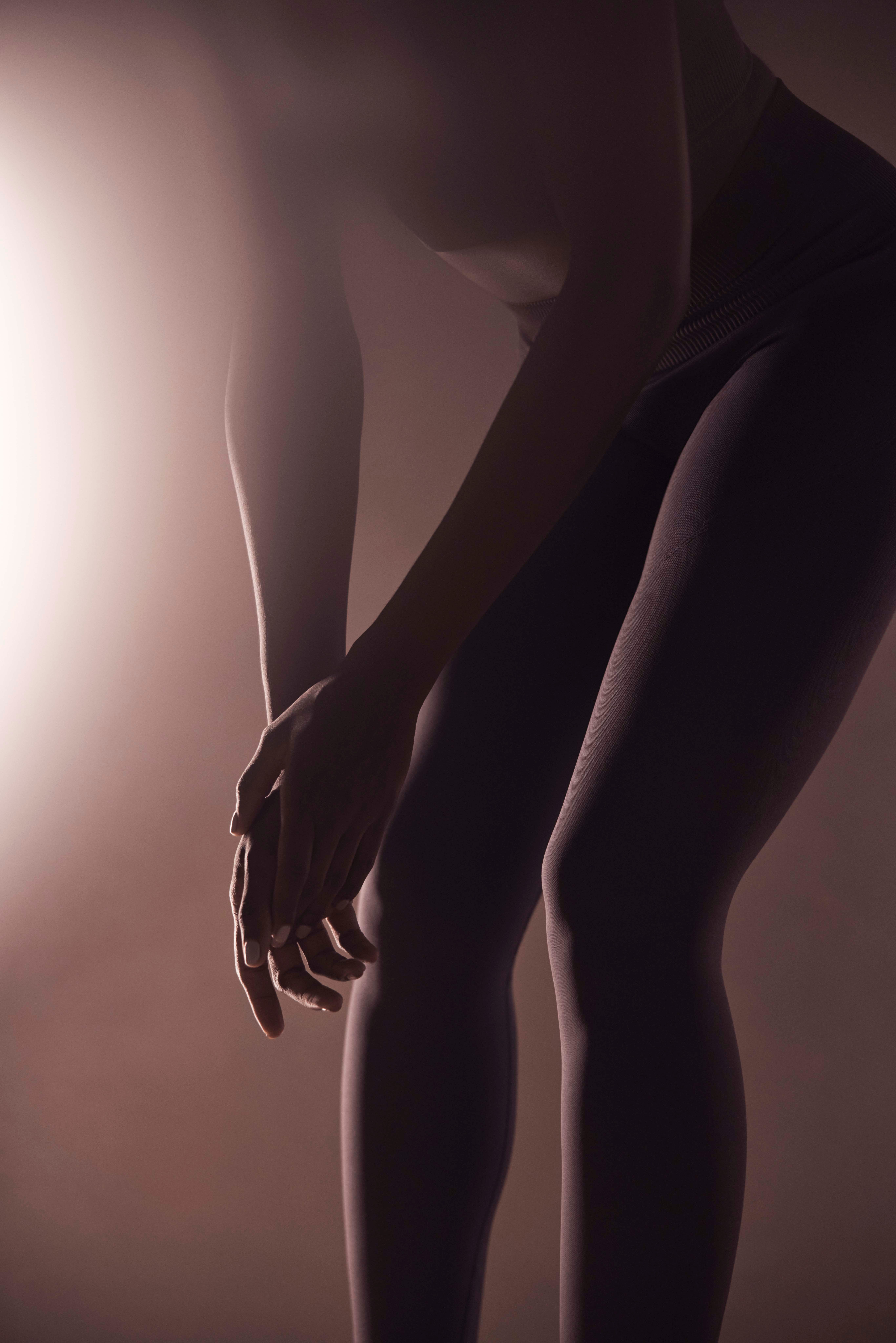 woman bending over cupping her hands by her knees