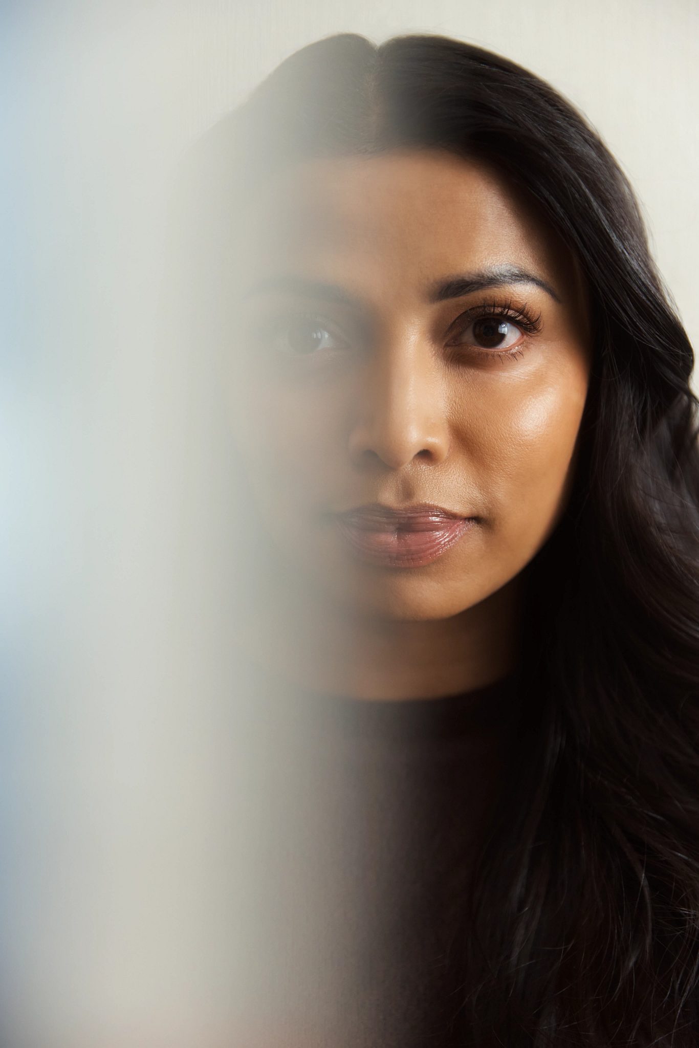 Closeup portrait of a woman's face with half of it blurred
