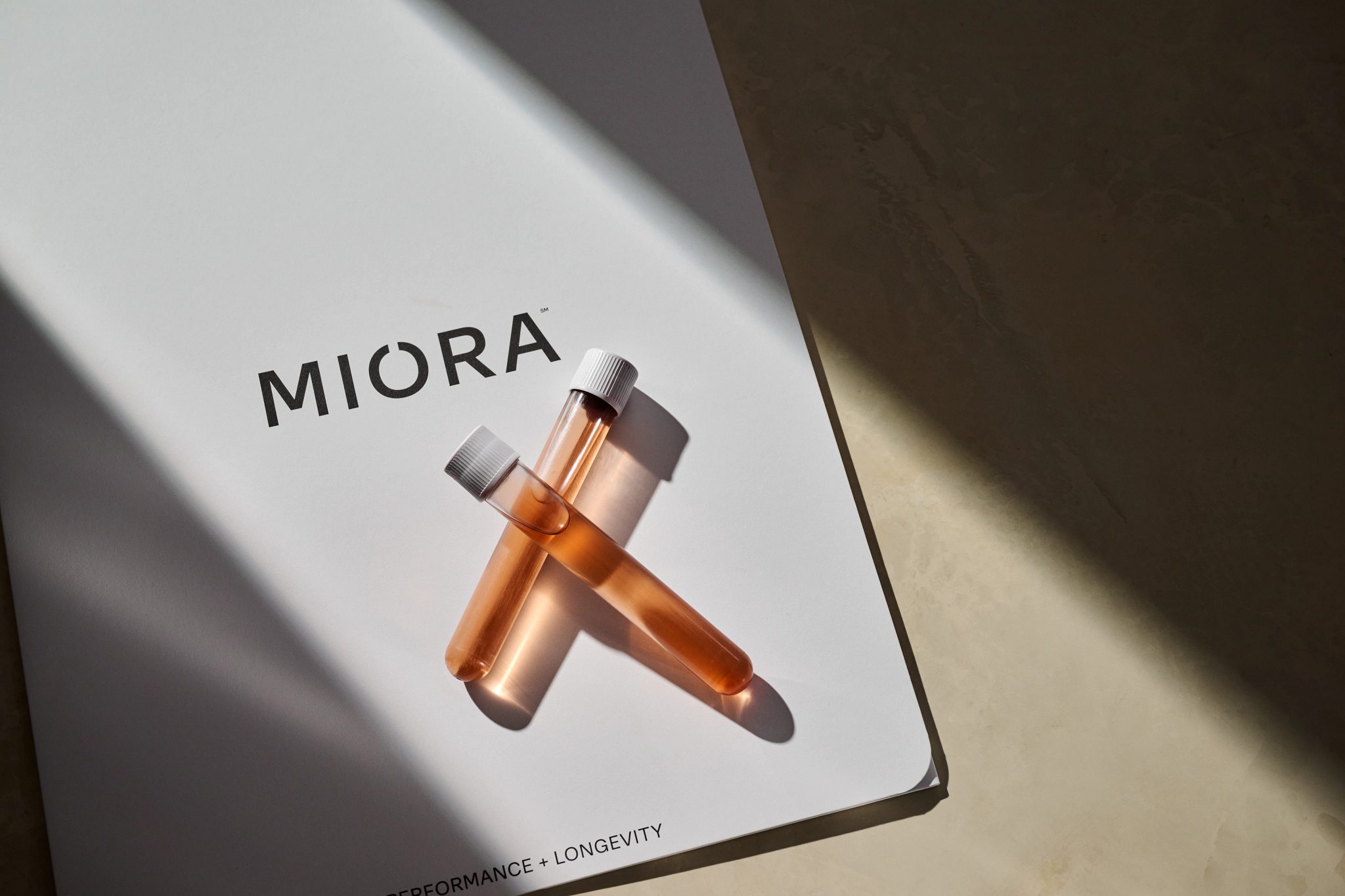 Two bloodwork test tunes sitting on top of a MIORA branded folder