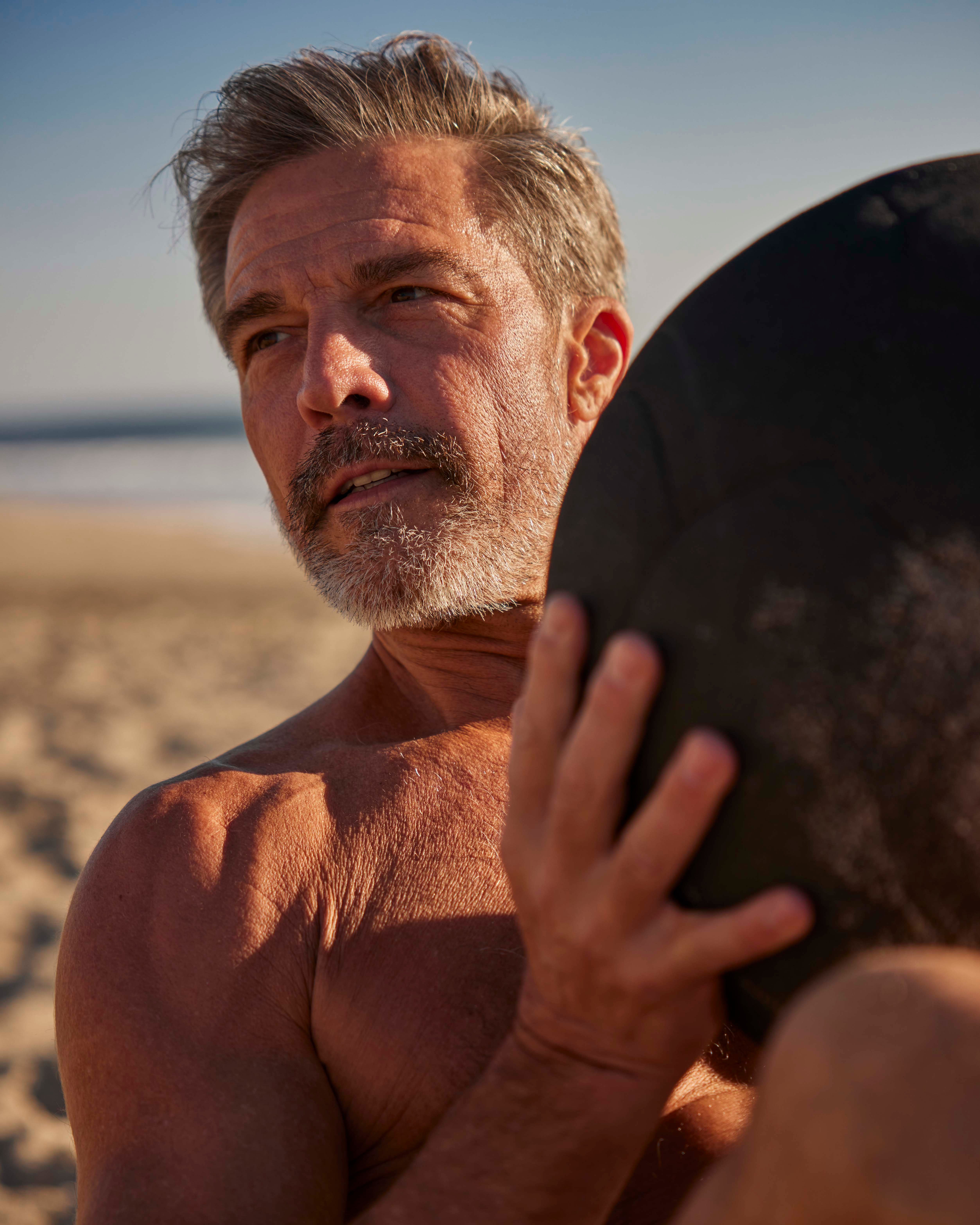 man working out on a beach with a ball