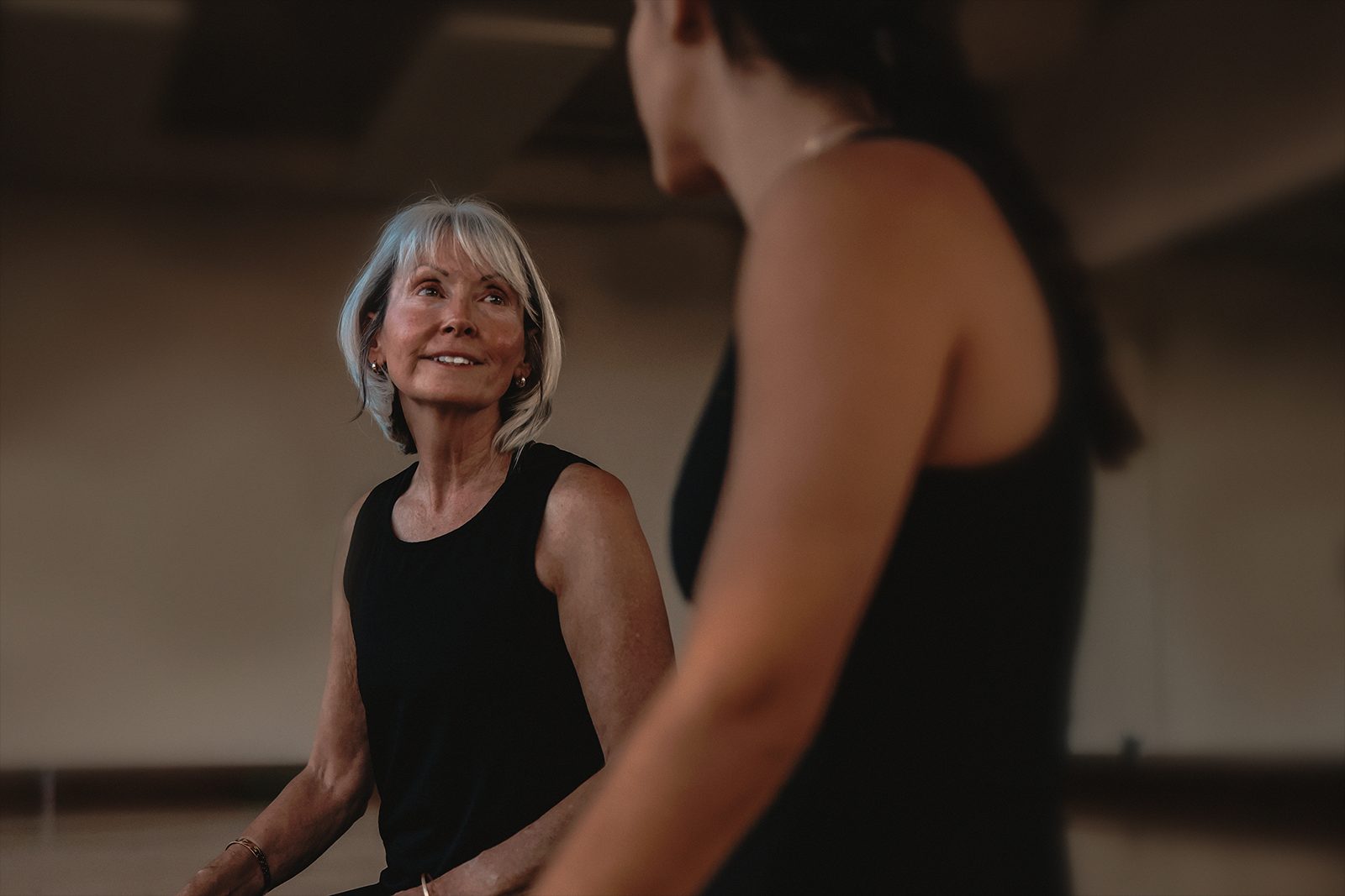 Two women chatting in a fitness room.