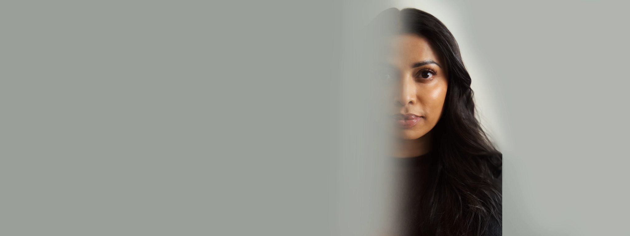 Closeup portrait of a woman's face with half of it blurred